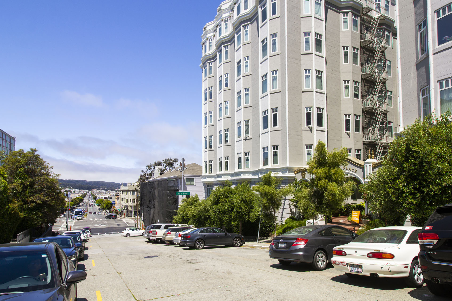 A parking lot with cars and a building in the background.