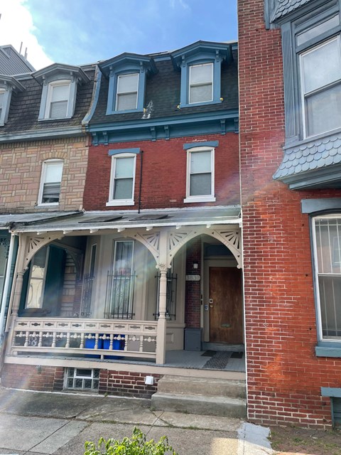 the front of a brick house with a porch
