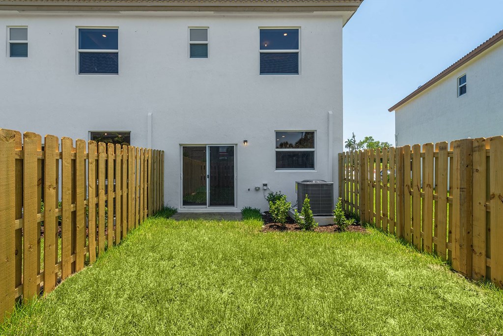 a yard with a fence in front of a house