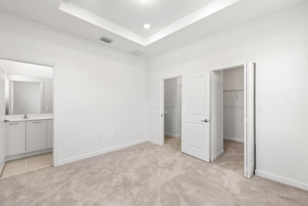 an empty bedroom with a closet and a bathroom