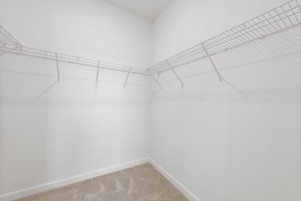 an empty room with white walls and wire racks on the wall