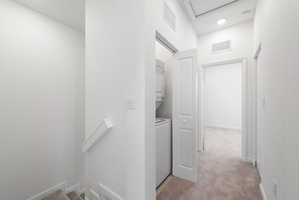 a renovated apartment with a hallway and a laundry room