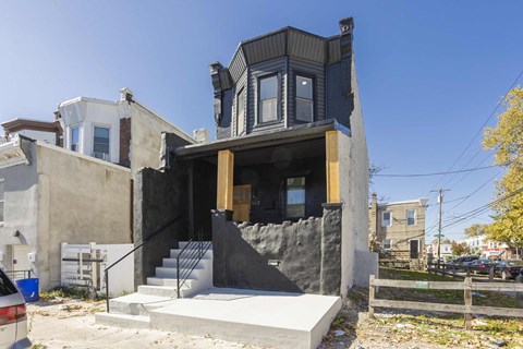A modern house with a black exterior and a large window.