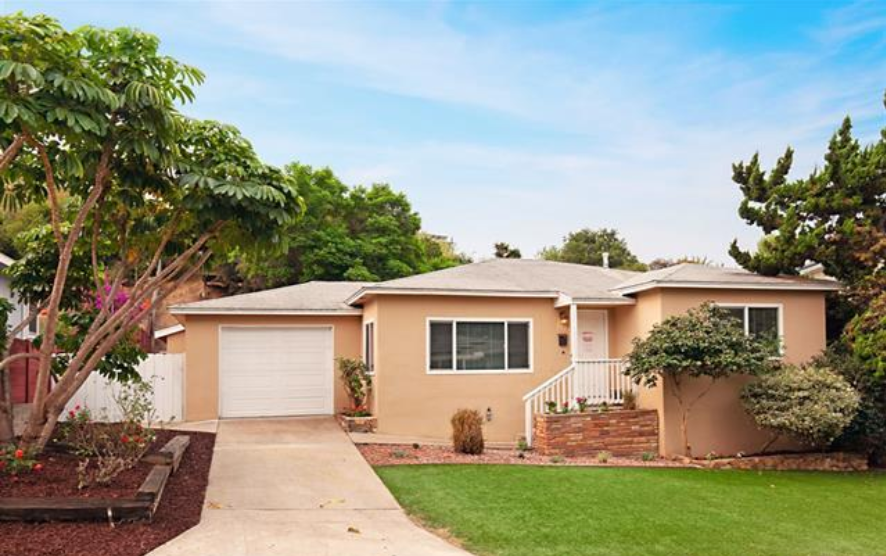 a beige house with a yard and a driveway