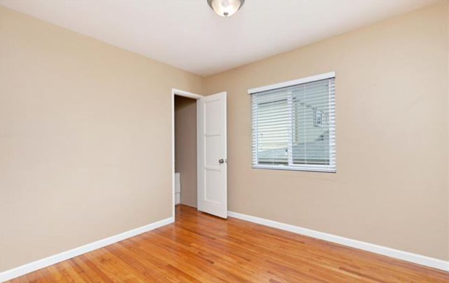 an empty living room with a window and a door