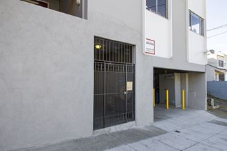 the front door of a white building with a black gate