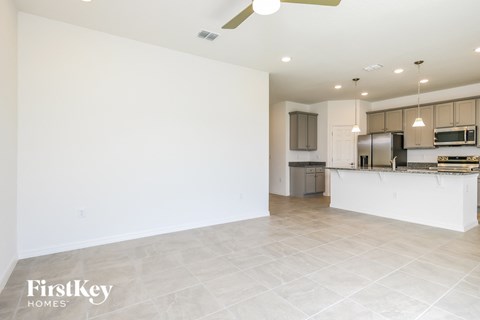 A spacious kitchen with a white countertop and a ceiling fan.