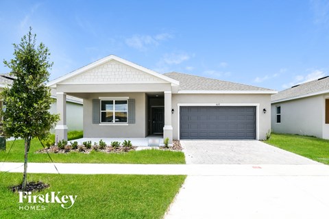 A white house with a garage door is for sale by FirstKey Homes.