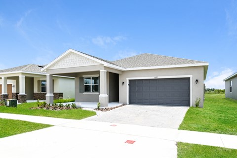 A house with a grey garage door and a white driveway.