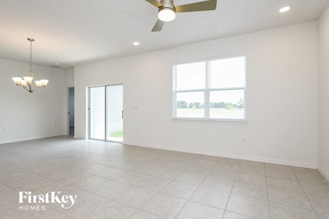 A spacious room with a ceiling fan and a large window.