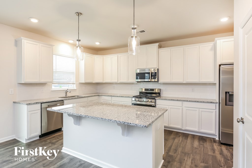 A kitchen with a granite countertop and white cabinets.