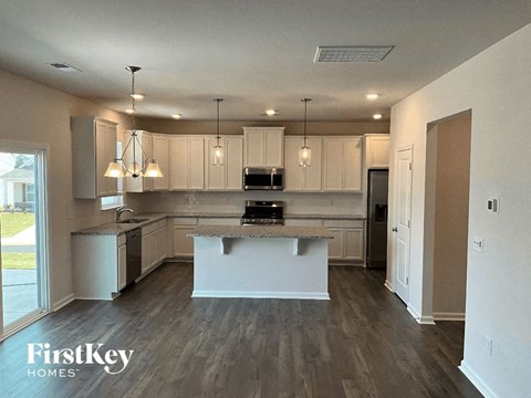 A kitchen with a large island in the middle and a dining area.