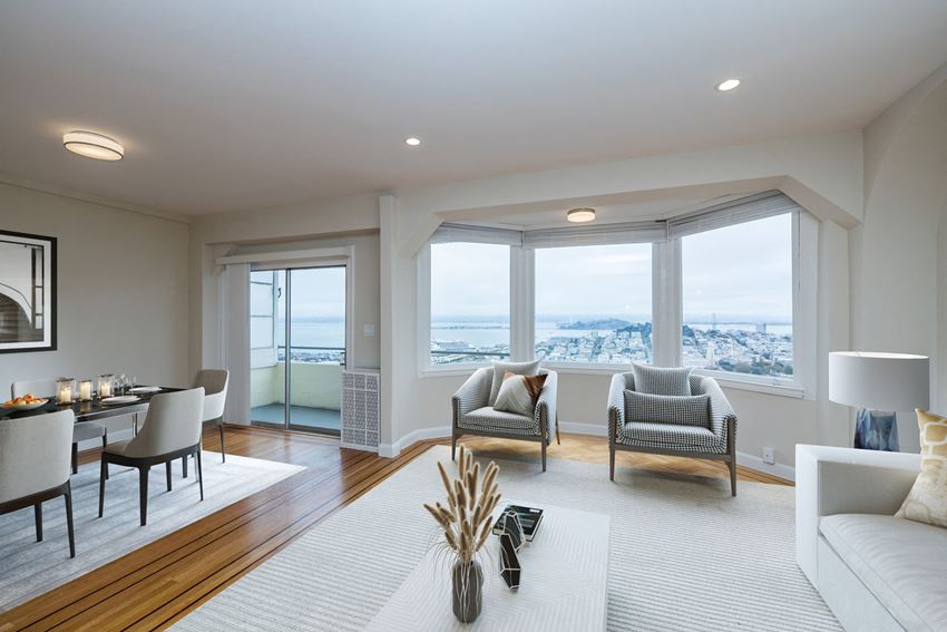 the living room has a view of the city and the ocean from the window