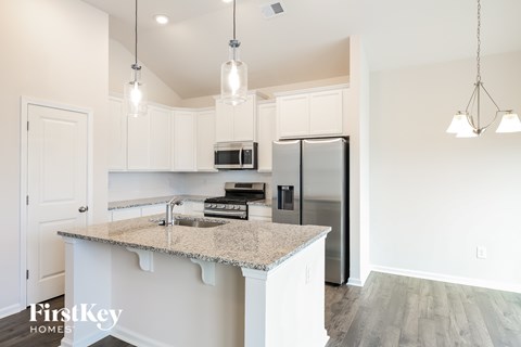 A kitchen with a granite countertop and stainless steel appliances.