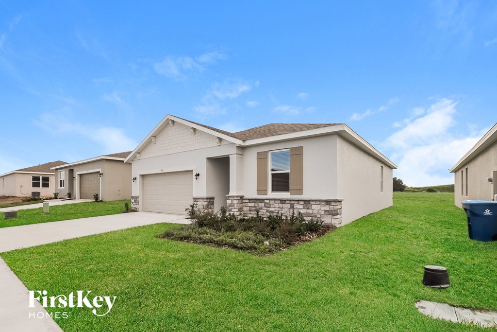 a beige house with a lawn in front of it