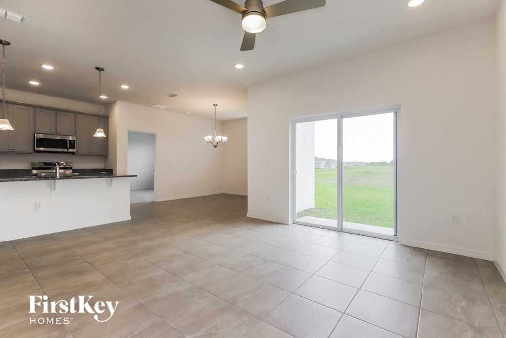 an empty living room and kitchen with a sliding glass door