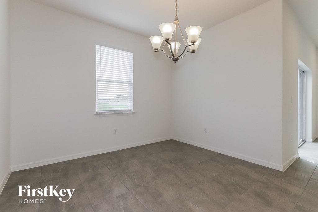 the living room of an empty house with a chandelier