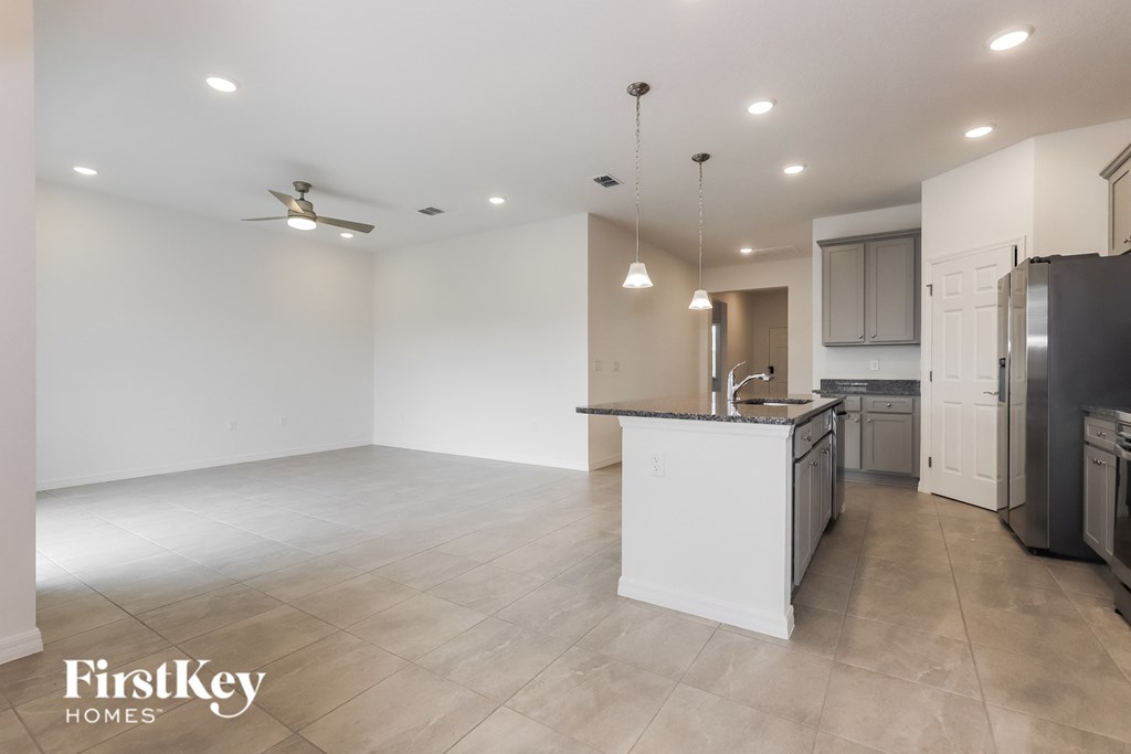 an empty kitchen and living room with white walls and tile flooring