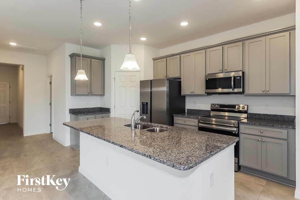 a kitchen with granite counter tops and white cabinets