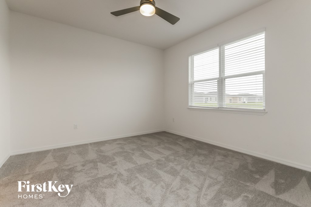 a bedroom with a ceiling fan and a window