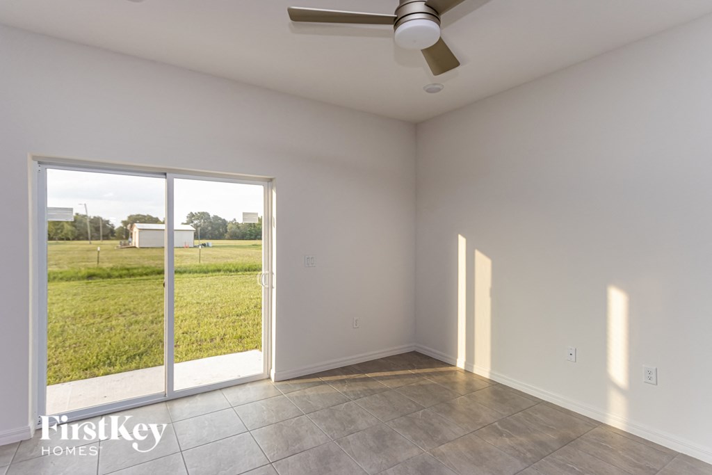 A room with a sliding glass door leading to a grassy area.