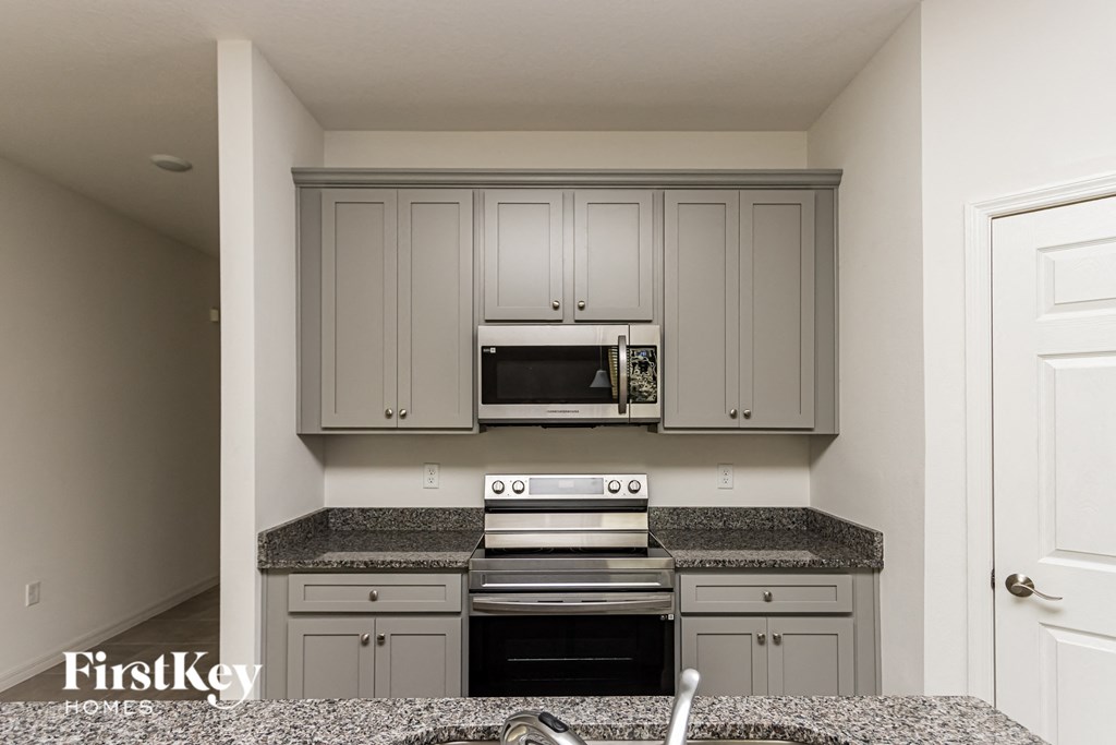 A kitchen with a stove top oven and microwave above it.