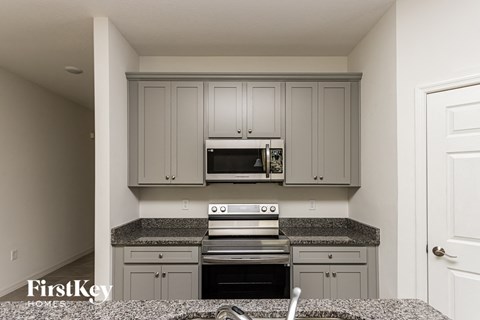 A kitchen with a stove top oven and microwave above it.