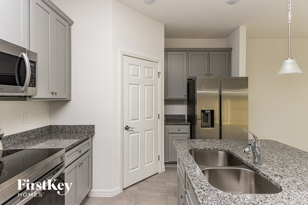 A kitchen with a sink, microwave, and refrigerator.