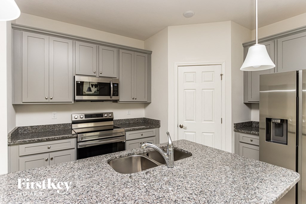 A kitchen with granite countertops and stainless steel appliances.