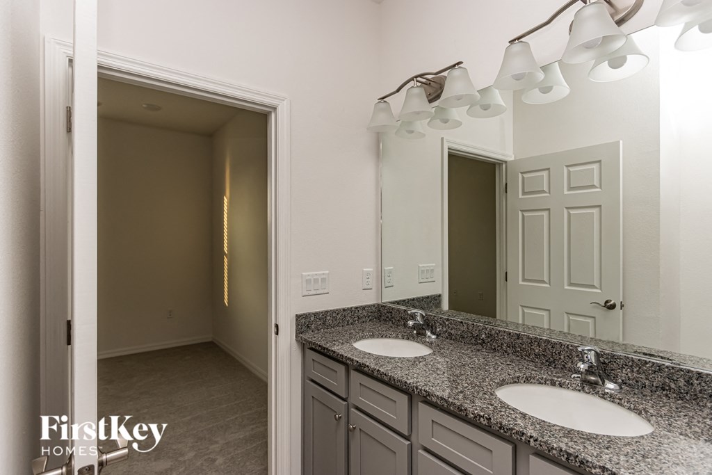 A bathroom with granite countertops and two sinks.