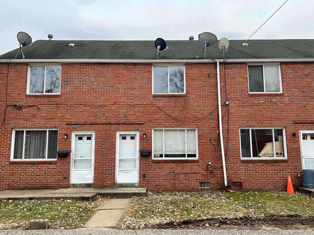 A red brick house with white doors and windows.