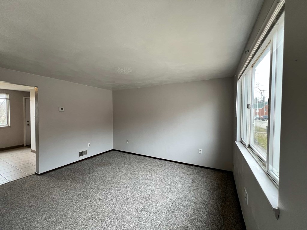 A room with a grey carpet and white walls.