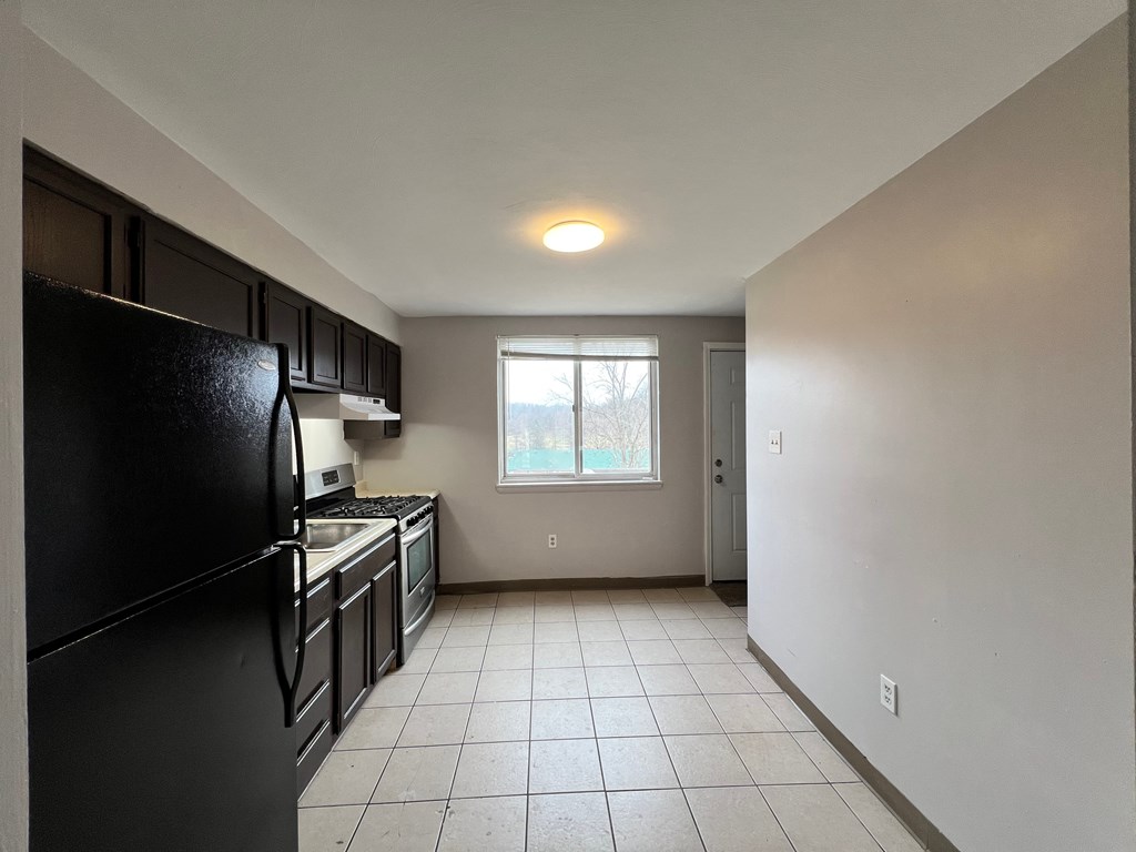 A kitchen with black appliances and white cabinets.