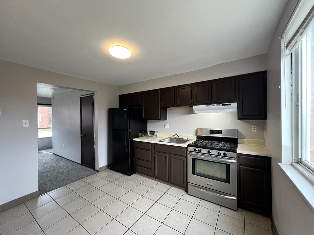 A kitchen with black cabinets and stainless steel appliances.