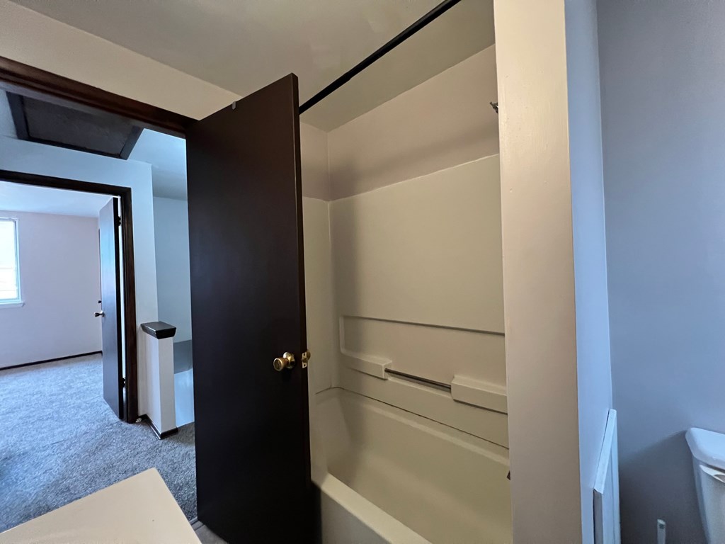 A bathroom with a toilet, sink, and a door.