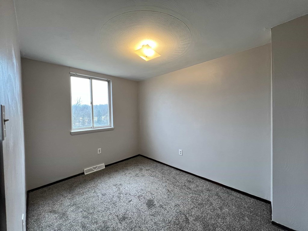 A room with a window and a ceiling light.
