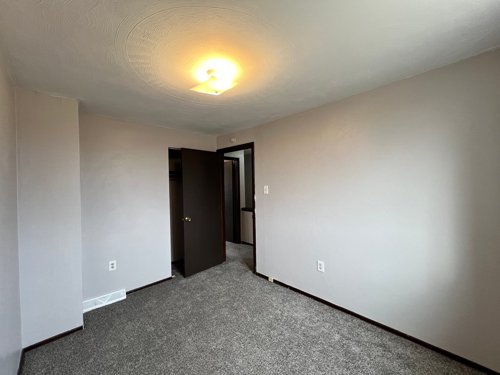 A room with a carpeted floor and a ceiling light.