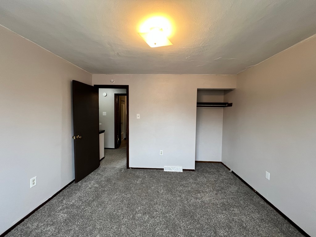 A room with a carpeted floor and a light on the ceiling.