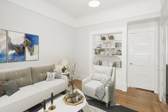 a living room with white furniture and a white door