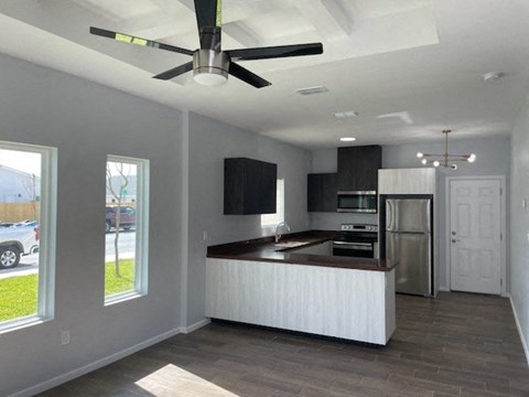 an empty kitchen with a ceiling fan
