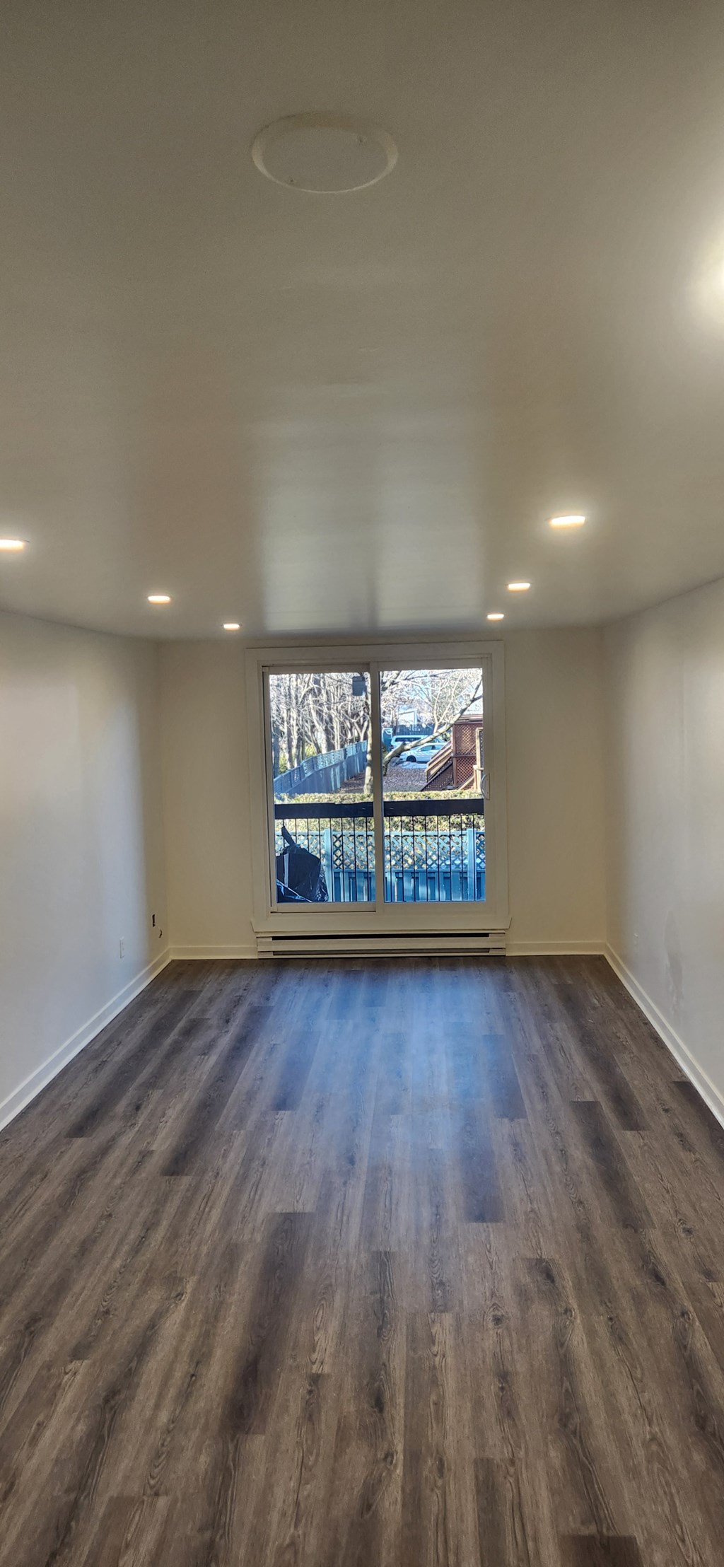 an empty living room with a large window