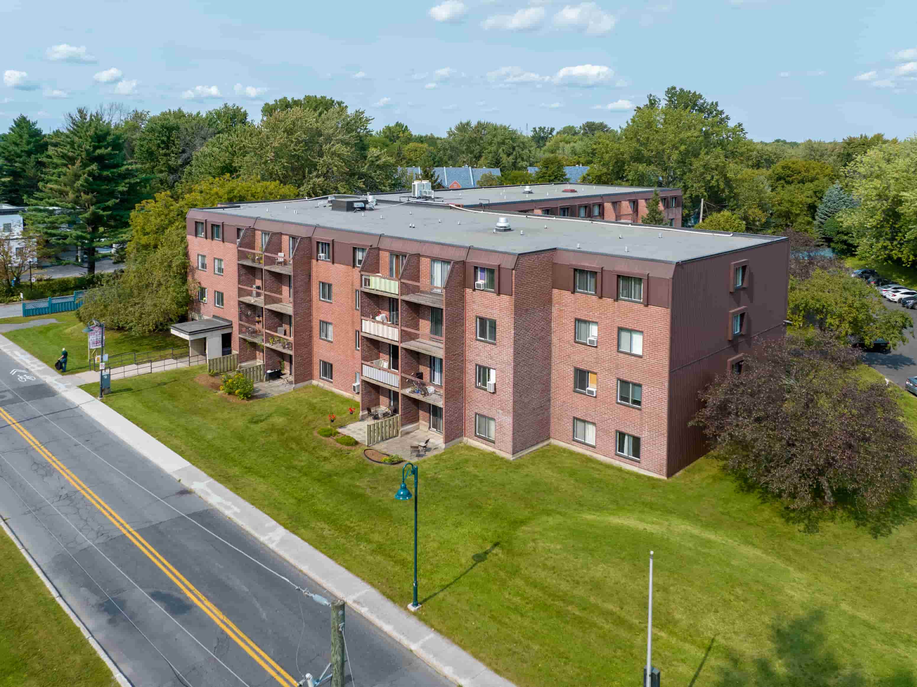 an aerial view of a brick apartment building on the side of a road