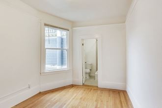 an empty room with a window and a door to a bathroom