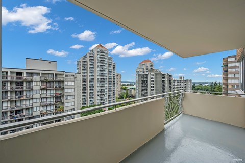 A balcony with a view of apartment buildings.
