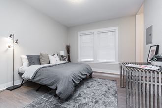 a bedroom with a bed and a radiator and a window