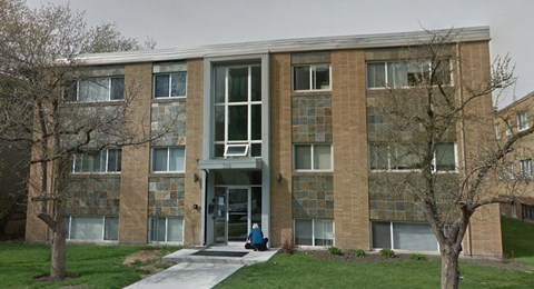 a woman sitting in front of a brick building