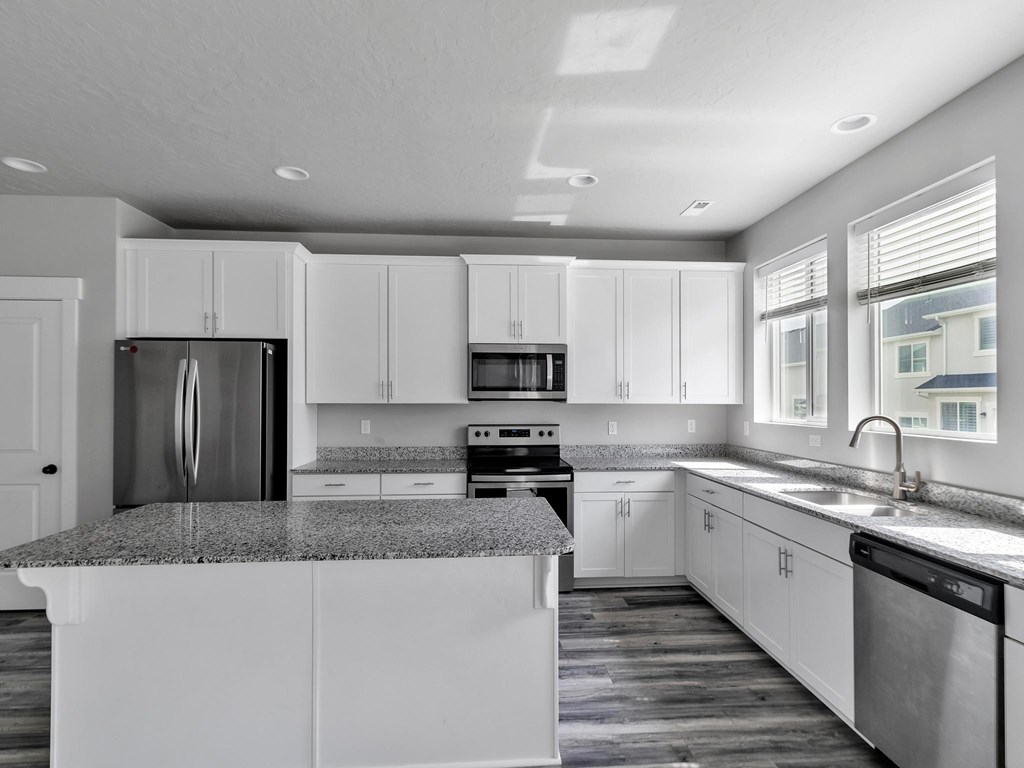 a kitchen with white cabinets and granite counter tops