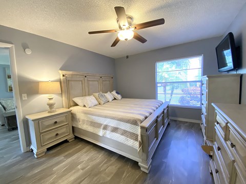 a bedroom with a bed and a ceiling fan