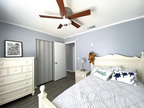 a bedroom with a bed and a ceiling fan