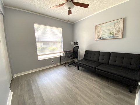 a living room with a couch and a desk